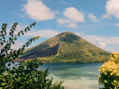 Scenic volcanic island landscape overlooking calm blue waters and lush tropical vegetation